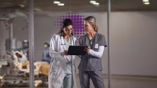 Two healthcare professionals discussing in front of monitor